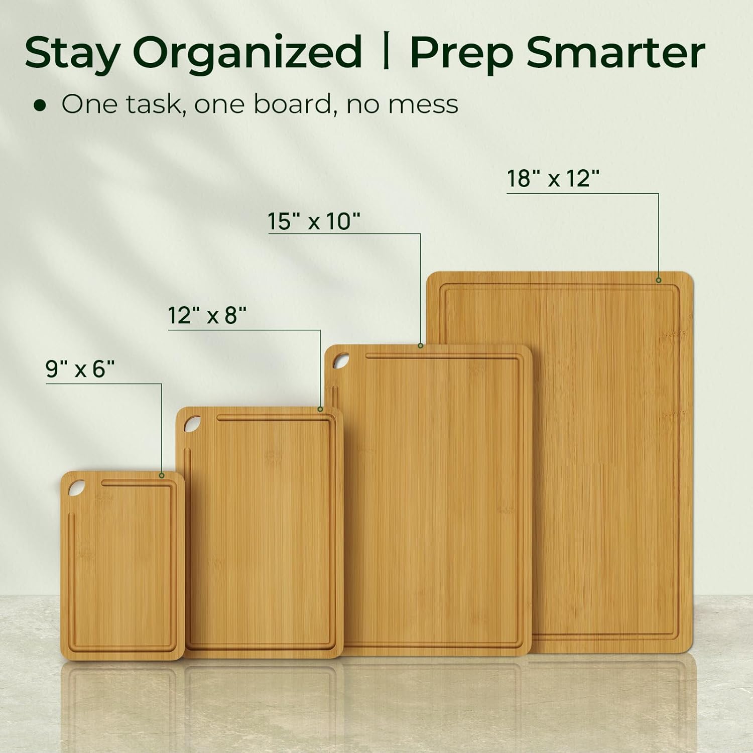 Four graduated natural bamboo cutting board sizes arranged for organized kitchen