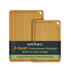 Two natural bamboo cutting boards with built-in handles and juice grooves